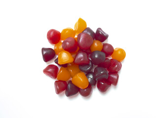 Group of red, orange and purple multivitamin gummies isolated on white background