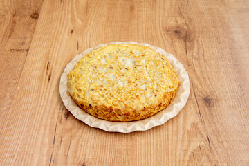 Spanish omelette with potatoes and eggs on a cardboard plate for home delivery