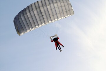 Parachute jumper jumping in tandem against a cloudless sky.