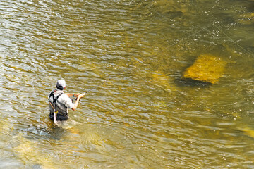 angler fisherman fishing in river with great equipment