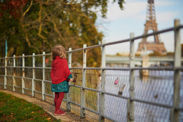 Adorable toddler girl playing in autumn park