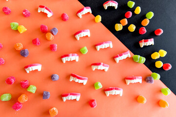 Happy Halloween decoration. Halloween candies on orange background.