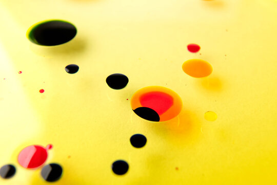 closeup ptoto of color ink float on yellow oiil