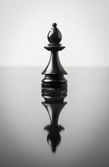 the bishop chess piece on white background with reflection in table.