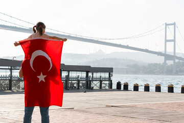 Little cute girl seat on father's shoulders in front of Bosphorus bridge (aka: 15 July Martyrs...