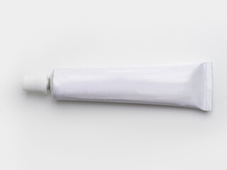 A blank white tube commonly used for pharmaceutical use or chemical products such as adhesives. Isolated on natural white background.