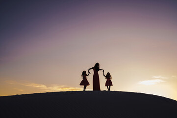 Fototapeta premium silhouette of mother and daughters