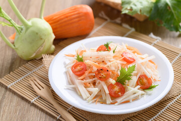 Salad with sliced kohlrabi, carrot, tomato and mizuna leaf on white dish, Vegan food, Healthy eating