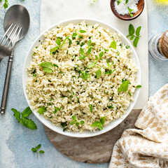 Cauliflower rice with herbs and lemon juice in a white bowl