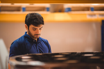 A male worker concentrated on his work job, working concept in uniform, closeup portrait worker employee in warehouse storage storehouse.