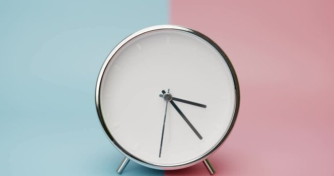 Close up zoom in detail - silver clock isolated on blue pink background, Time starts walking at 3 o'clock, Timelapse 3 hour.