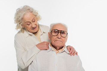 elderly woman gently hugging and looking at husband isolated on white