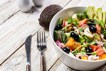 Delicious and healthy summer seafood salad. Mussels, shrimp, salmon, tomatoes, ice salad, avocado, red onion, Swiss chard, olives, and olive oil. Mediterranean Kitchen, rustic background. Copy space