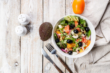 Top view delicious and healthy seafood salad. Mussels, shrimp, salmon, tomatoes, ice salad, avocado, red onion, Swiss chard, olives, and olive oil. Mediterranean Kitchen, rustic background. Copy space