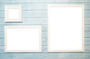 White frames for a picture with copy space on a wooden turquoise background for mockup