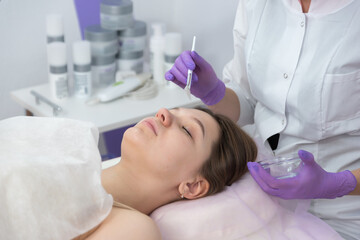 Obraz na płótnie Canvas Facial brush peel retinol treatment. Beauty woman peeling procedure. Cosmetology young girl therapy.Hyaluronic acid.