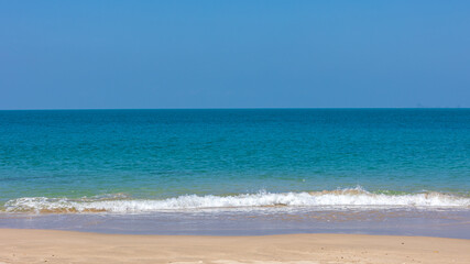 Selective focus sea wave bubbles on a peaceful beach in tropical. Crystal clear white water bubbles at sandy beach