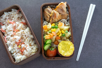 レモン風味弁当(鶏肉のレモン風味焼き、ポテトとミックスベジタブルのバター炒め、ミニトマト)（漆、黒背景、二段）