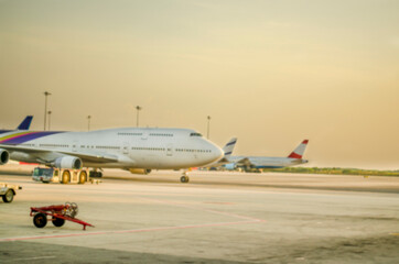 Blurred background airport with many airplanes at beautiful sunset