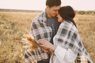 Happy couple in love in wheat field at sunset