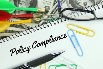 pen, click paper, paper money, arrows and the word policy compliance
