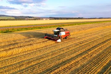 Aerial view of a combine harvester working in a wheat field. Seasonal wheat harvesting. Agriculture. Drone shooting