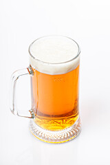 Mug of cold light beer on a white background. Beer foam and bubbles. Vertical shot. Traditional light alcoholic drink shot. Close-up