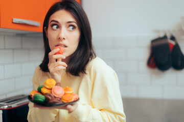 Woman Eating Macarons Feeling Guilty and Hiding - obrazy, fototapety, plakaty