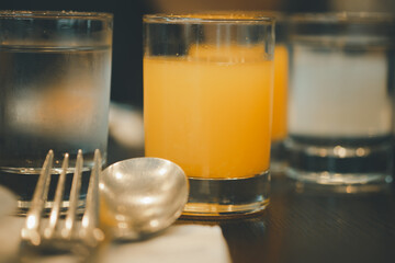 Glass of water and orange juice served on table in a restaurant