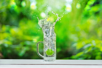 Fruits falling into the glass that sits on the bar.  water spread