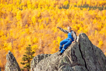 mature tourist posing on the rocks of the mountain round hill on the Alabiya ridge in the Ural...