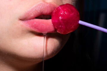 Licking candy. Lollipop model. Woman lips sucking a candy. Oral sex blow job concept. Glamor...