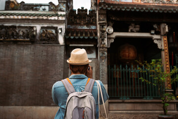 He carried his bag and held the camera up to take a picture.