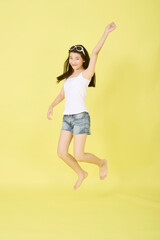 Fototapeta na wymiar Happy woman jumping on yellow summer backgrounds