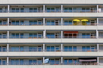 Fototapeta premium Facade of a big apartment building with yellow sunshades on one of the balconies