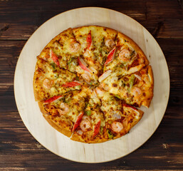 Background, banner and Close up on decorated homemade seafood pizza with shrimp, crab sticks, bell peppers topping on wooden tray