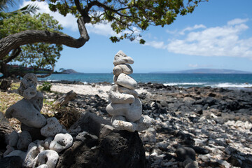 Stones pyramid on pebble beach symbolizing stability, zen, harmony, balance.