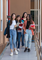 Obraz premium Group of young attractive asian girls college students walking together in university campus smiling with joy. Concept for education and college students life