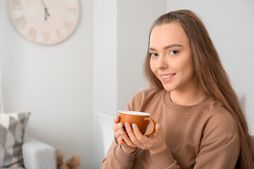 Beautiful woman with cup of coffee at home