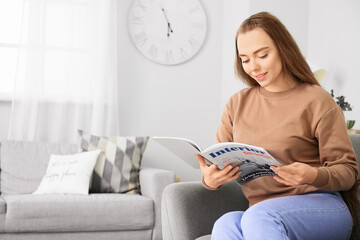 Beautiful woman reading magazine at home