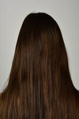 Naklejka premium Back view of a woman with long straight black hair. Long hair texture background close up.