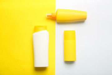 Bottles of cosmetic products on color background