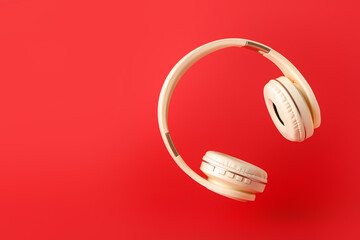 Modern headphones on color background