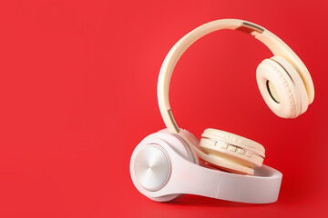 Modern headphones on color background