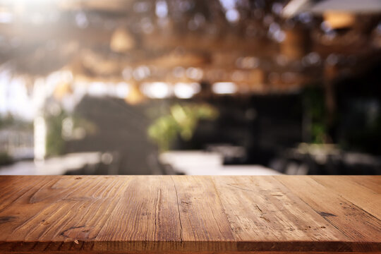 background Image of wooden table in front of abstract blurred restaurant