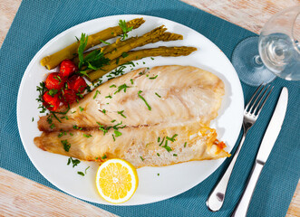 Healthy dinner, oven baked perch fish with vegetables and lemon