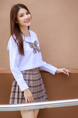 Cute and young girl wearing Japanese, Korean style schoolgirl uniform and pose to camera with fun...