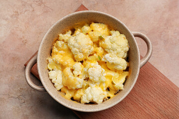 Pot with tasty cauliflower and cheese on color background