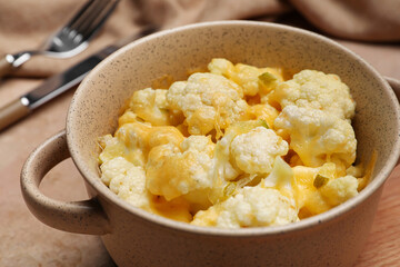 Pot with tasty cauliflower and cheese on color background, closeup