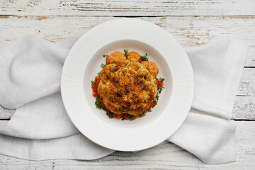 Plate with tasty fried cauliflower on light wooden background